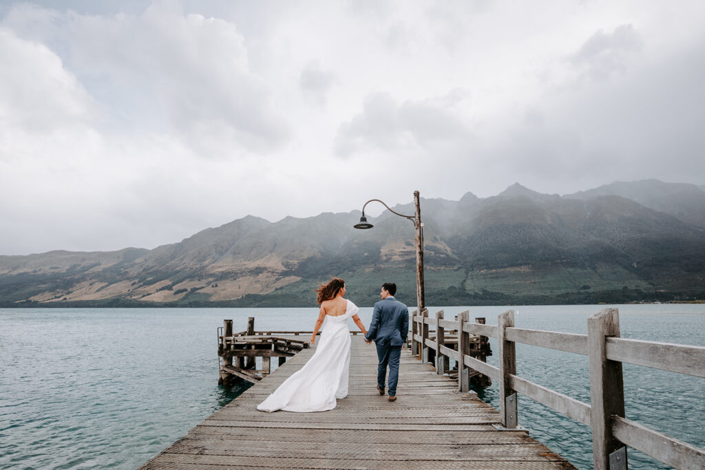 bride and groom kissing at a wharf in glenorchy new zealand