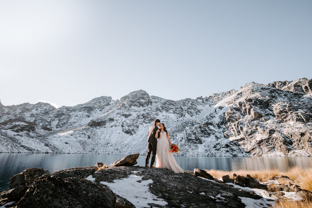 bride and groom kissing by lake Hope in queenstown new zealand
