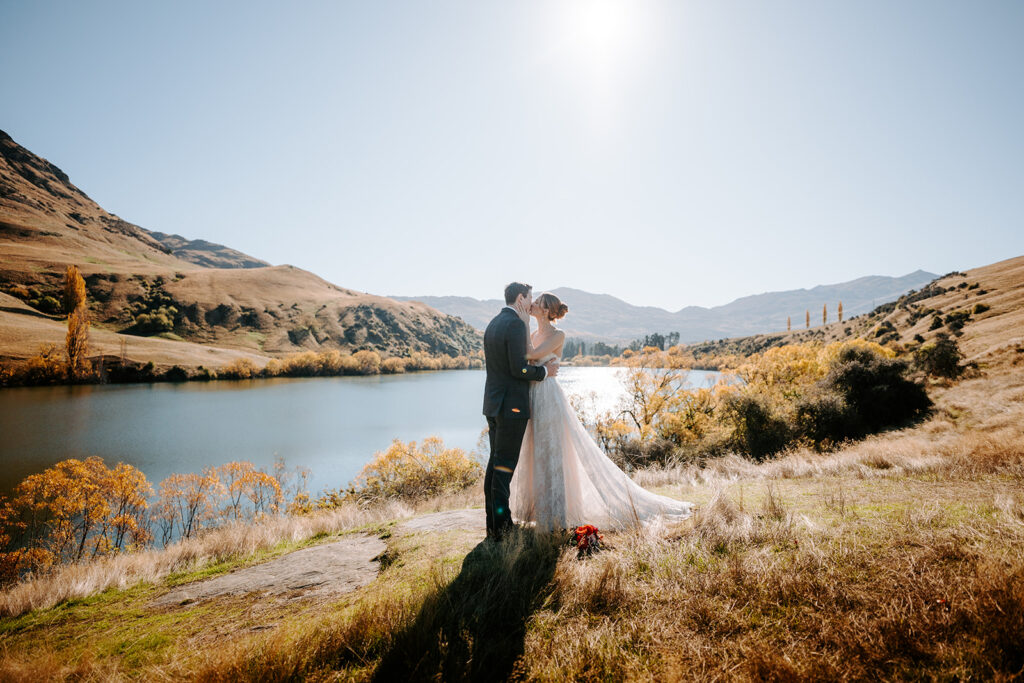 bride and groom kissing by lake johnson in queenstown new zealand