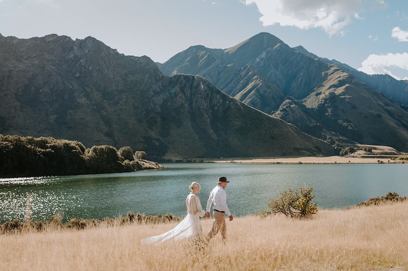 bride and groom walking in a field