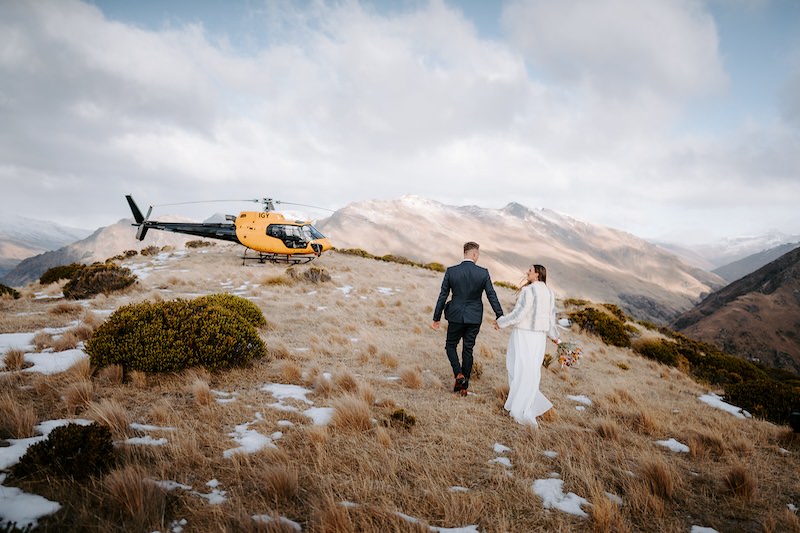 bride and groom walking towards helicopter at roundhill queenstown